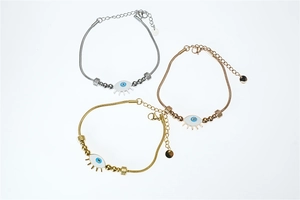 Vue détaillée des breloques œil grec en argent, or et or rose sur bracelets en acier titane