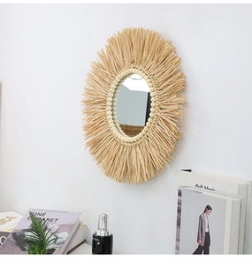 Dettaglio specchio da parete Boho con frange in rafia naturale e perline di legno su muro