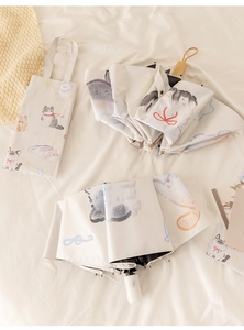 Detail of cute cat pattern folding umbrella with matching carrying storage bag