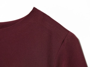 Detailed view of the shoulder and neckline on this wine red balloon hem dress