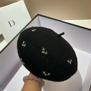 Close-up of black lamb wool beret featuring silver star rhinestones in a white gift box
