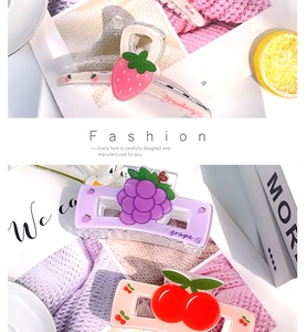 Détail de trois pinces à cheveux en acrylique aux motifs de fraise, de raisin et de cerise