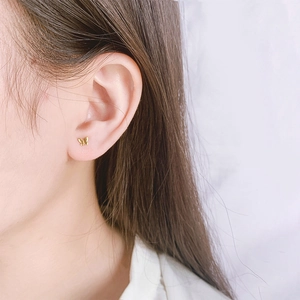 Golden butterfly stud earrings in S925 sterling silver worn by a female model