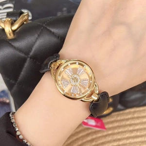 Close-up of a gold luxury watch with diamond dial and black leather strap for women