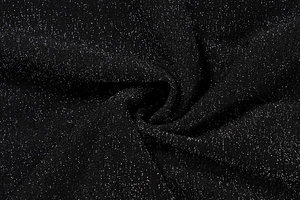 Detail of black glitter fabric with silver sequins showing soft draped pleats texture