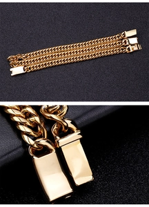 Macro detail of a heavy gold stainless steel Cuban link bracelet with a square clasp