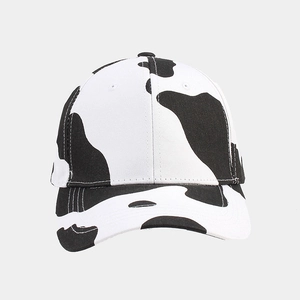 Macro detail of cow print baseball cap with black and white spots on durable canvas fabric