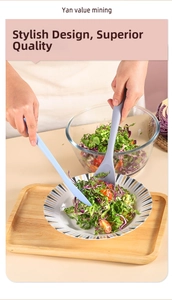 Hands using blue silicone spatula and purple spoon to serve fresh salad in a glass bowl