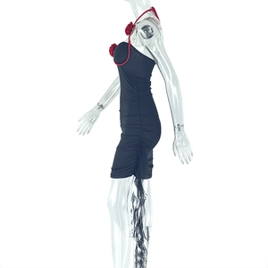 Détail de l'applique fleurie rouge et fronces sur robe moulante noire ajustée