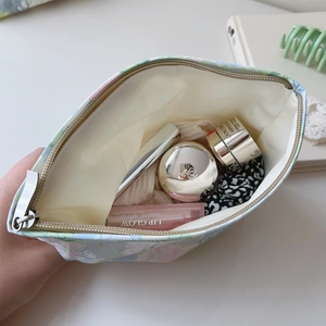 Detail view of floral makeup bag interior featuring large opening and light yellow lining