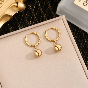Minimalist gold ball hoop earrings with polished beads on beige jewelry box
