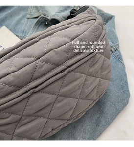 Close-up of grey quilted crossbody bag showing soft nylon texture and metallic zipper