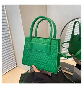 Gros plan d'un mini sac carré vert vif en similicuir avec une texture en losanges