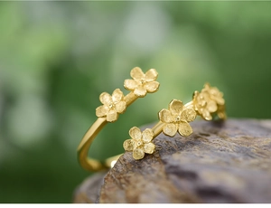 Detailed macro view of gold S925 silver ring featuring five matte floral petals on stone