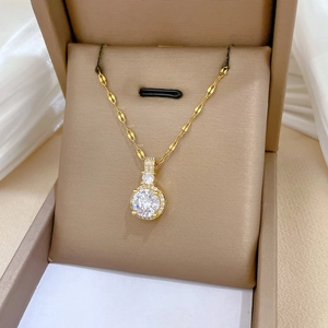 Vue macro d'un collier plaqué or avec pendentif en zircon brillant dans un coffret cadeau