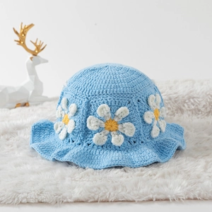 Close-up of blue hand-crocheted bucket hat with detailed 3D daisy flower embroidery