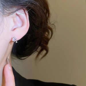Nahaufnahme eines Sternohrrings aus Lavendelkristall mit S925 Silber am Modellohr
