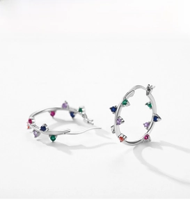 Macro detail of S925 sterling silver hoop earrings with multi-colored cubic zirconia stones