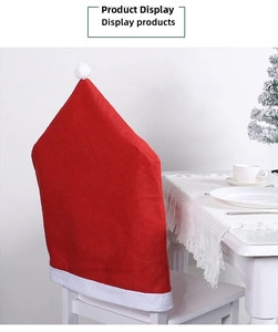 Detail of red Santa hat chair cover with white plush pompom on a dining room chair