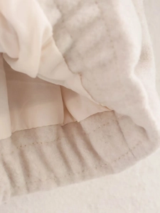 Gros plan détaillé des coutures et du tissu polaire doux de ce blouson beige