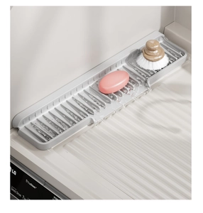 Detailed view of the sloped silicone drainage mat with non-slip ridges and cleaning tools