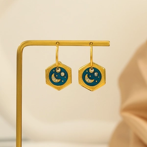 Goldene Sechseck-Ohrringe mit blauem Emaille und Sternen auf einem Schmuckständer