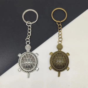 Turtle keychain set in silver and bronze finish on a minimalist diagonal background