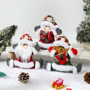 Close-up of Santa, Snowman and Bear plush ornaments on a snowy festive background