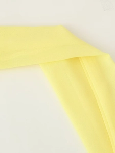 Close-up detail of smooth yellow chiffon fabric texture and high-quality material weave