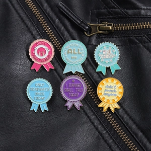 Detailed close-up of six enamel award pins with funny slogans on black leather jacket