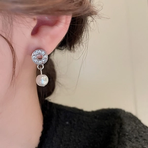 Close-up of silver water drop pearl earrings with inlaid crystals on a female model