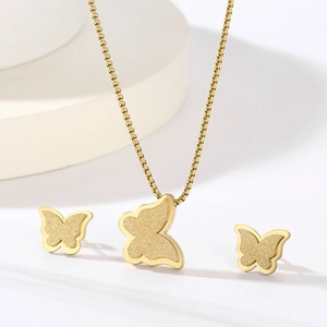 Detailed close-up of golden butterfly necklace and earrings set with cubic zirconia stones