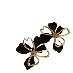 Elegant double-layer hollow flower stud earrings in black and gold finish on white background