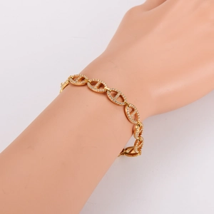 Sparkling gold pig nose link bracelet with dense pavé crystals on a jewelry hand model