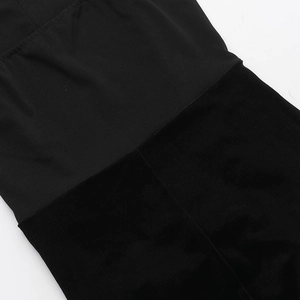 Close-up of elegant black velvet and matte stretch fabric patchwork on a cocktail dress