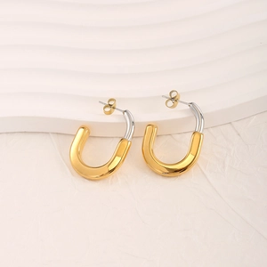 Minimalist 18K gold and silver two-tone U-shaped stainless steel earrings on a textured background