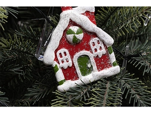 Macro shot of gingerbread house Christmas ornament with red and green resin details