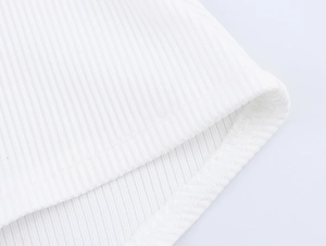 Macro shot of white ribbed knit fabric texture and high-quality hem stitching details