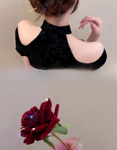 Close-up of golden rose hair pin with red velvet petals and glowing light details