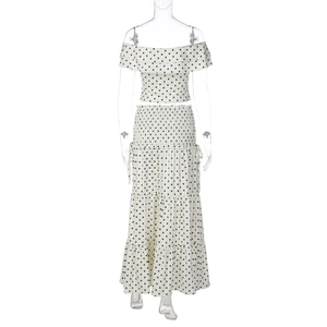 Detail of polka dot crop top with ruffled neckline and smocked waist tiered maxi skirt