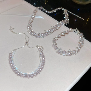 Detailed view of silver zircon rose and pearl necklace set with shimmering star effects