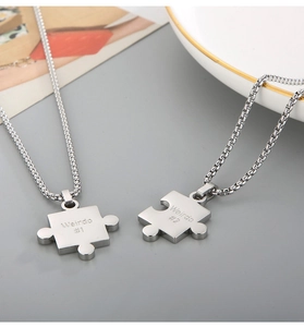 Detail of stainless steel puzzle necklaces with Weirdo 1 and Weirdo 2 engravings