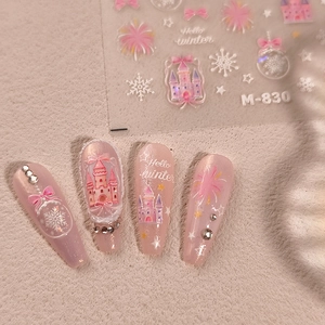 Pink winter nail stickers with castle and snowflake patterns applied on long nails