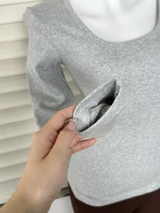 Dettaglio delle cuciture e della morbida trama in modal sulla maglia grigia con scollo a U
