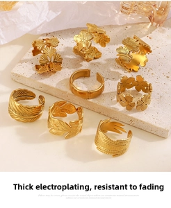 Detail view of 8-piece adjustable gold leaf rings including ginkgo and feather patterns