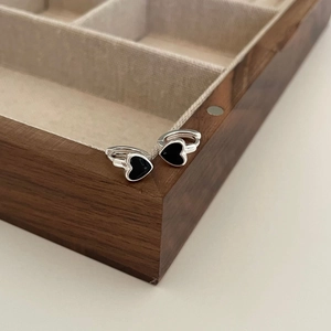 S925 sterling silver heart earrings with black enamel hanging on a dark wood box