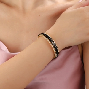 Luxurious wide gold cuff bracelet featuring double rows of black marquise cut stones and pavé zircons