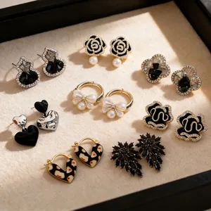 Selection of black zircon floral and bow earrings on beige velvet jewelry display