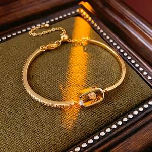 Detailed close-up of 18k gold-plated bangle featuring sliding cubic zirconia crystals