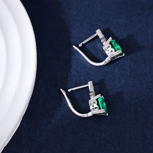 Detailed close-up of S925 sterling silver earrings featuring green emerald gemstones